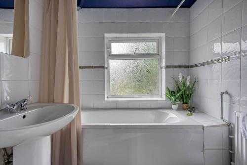 诺丁汉Stylish Home - Fast Wi-Fi-FREE Parking的带浴缸、水槽和窗户的浴室