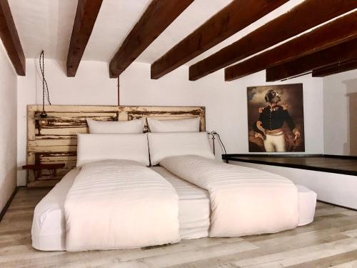 马略卡岛帕尔马Dog Admiral - Urban Guest House的配有木制天花板的客房内一张白色大床
