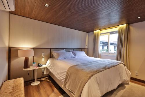 格拉玛多Serrazul Hotel Distributed By Intercity的一间卧室设有一张大床和一个窗户。