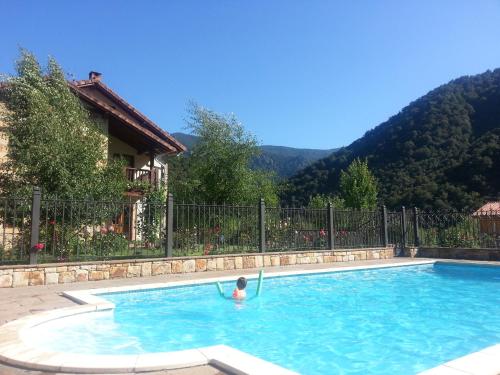 Pesaguero-La Parte波萨达萨尔瓦多酒店的在山地游泳池游泳的人
