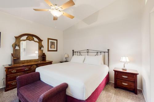 土桑Tucson National #8689的一间卧室配有一张床、一把椅子和镜子