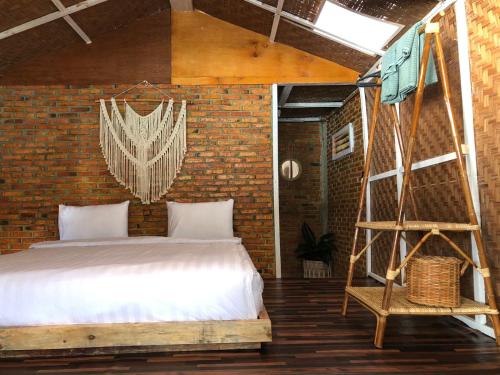 图克图克Hub Tata Guesthouse的一间卧室设有一张床和砖墙