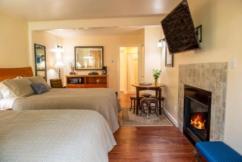 Little RiverInn at Buckhorn Cove的一间卧室设有两张床和一个壁炉