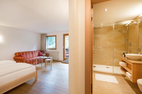加尔盖伦Familienhotel Mateera Gargellen / Montafon的客房内设有带水槽和淋浴的浴室