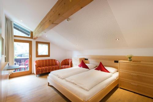 加尔盖伦Familienhotel Mateera Gargellen / Montafon的一间卧室配有一张带红色枕头的床