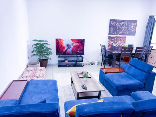 迪拜Hawana Hostel的客厅配有蓝色的沙发和电视