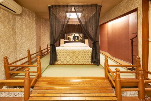 ホテル　モモ的一间卧室配有一张床,楼梯通往客房