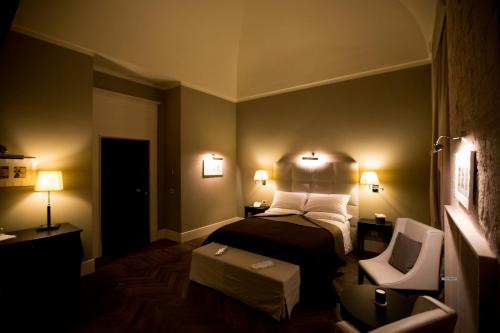 图里Relais Il Santissimo的配有一张床和一把椅子的酒店客房