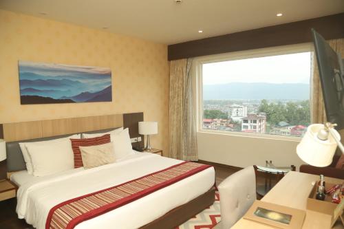 巴拉特布尔Vivanta Chitwan Bharatpur的酒店客房设有一张床和一个大窗户