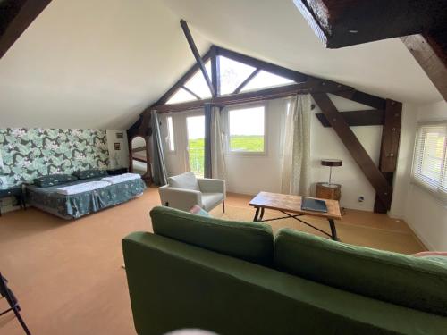 Lamothe-MontravelGites le Mathelin的客厅设有绿色沙发和窗户。