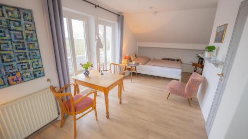 纽哈灵吉塞尔Schillhörn - Urlaub mit Wasserblick的一间带桌椅的客厅和一间卧室