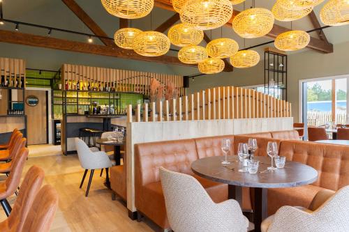 滨海贝尔克贝尔克梅尔多米奥度假酒店 的餐厅配有桌椅和灯光