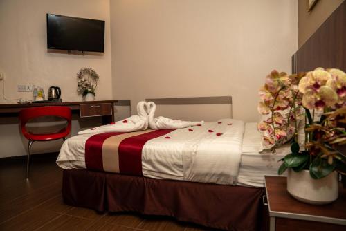 怡保Hotel Eastana Ipoh的一间卧室配有一张床、一张书桌和一台电视