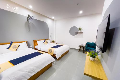 广义Khách sạn Lavie Hotel Quảng Ngãi的酒店客房设有两张床和一台平面电视。