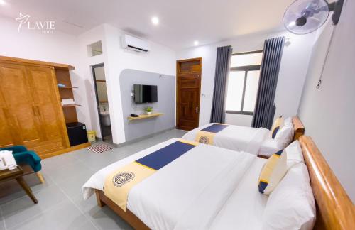 广义Khách sạn Lavie Hotel Quảng Ngãi的一间带两张床和电视的卧室