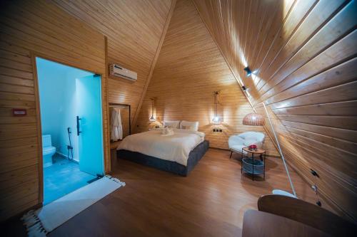 艾卜哈Terhabb Cottages的卧室配有一张床铺,位于带木墙的房间内
