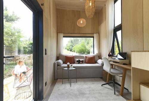 韦尔图La tiny house de la Blandinière的带沙发和窗户的客厅