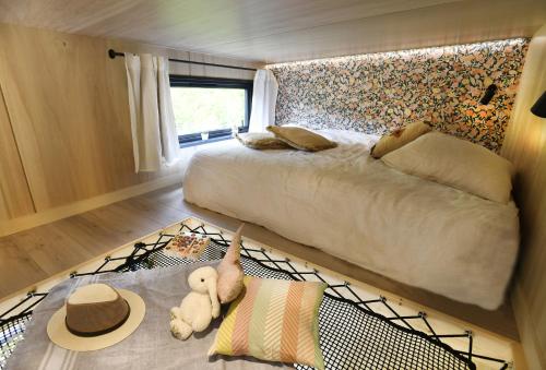 韦尔图La tiny house de la Blandinière的卧室配有一张床,地毯上配有泰迪熊