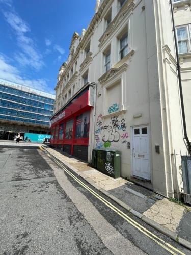 布莱顿霍夫Flat in Brighton city centre的一条空的街道,上面有涂鸦的建筑