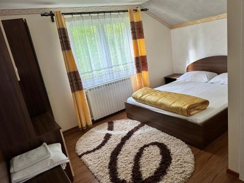 Statjunea BorsaPensiunea 3flori de Colț的卧室配有一张床,地板上铺有地毯