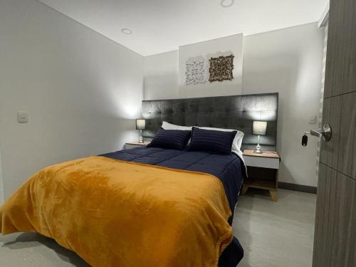 波哥大Magnifico y confortable apartamento amoblado # 303的一间卧室配有一张大床和两盏灯。