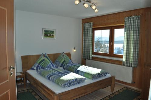 Vordergöriach哈斯霍夫民宿的卧室配有带枕头的床铺和窗户。