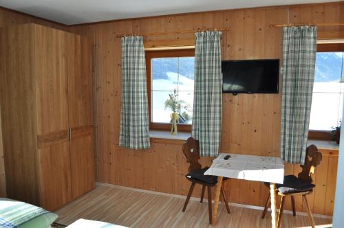 Vordergöriach哈斯霍夫民宿的一间配备有桌子和两把椅子及一台电视的房间