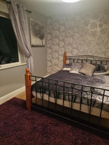 特拉利Shanadune的一间卧室配有一张带锻铁框架的床