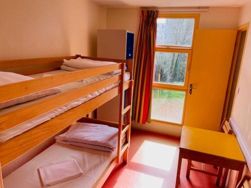 雷恩Auberge de Jeunesse HI Rennes的客房设有两张双层床和一扇窗户。