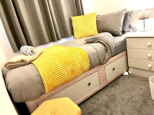 曼彻斯特Spacious 3 Bedroom House - Sleeps 5的一张床上的黄色毯子,放在房间里