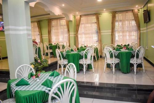 WebuyeGLAMOUR APOLLO HOTEL的配有绿色和白色桌椅的房间