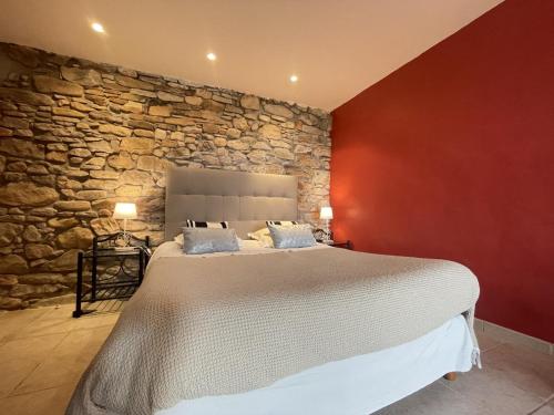 乌瑞基尼Chambres d'hôtes MANTTU的一间卧室设有一张带石墙的大床