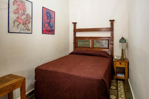 普埃布拉Hotel Travel的卧室配有一张床,墙上挂有两张照片