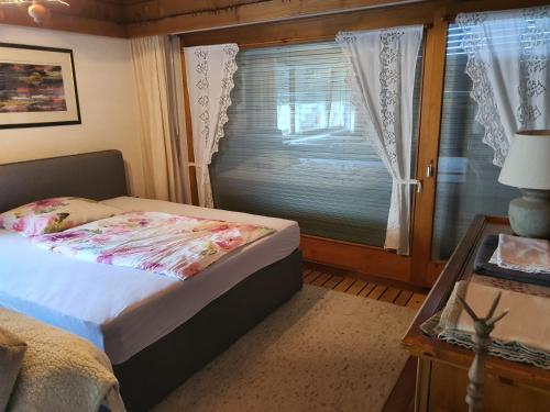 SchlinsDreamlandRanch Vorarlberg的一间卧室设有一张床、一个窗口和一张桌子