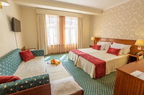 戈韦阿Hotel Eurosol Gouveia的酒店客房,设有两张床和一张沙发