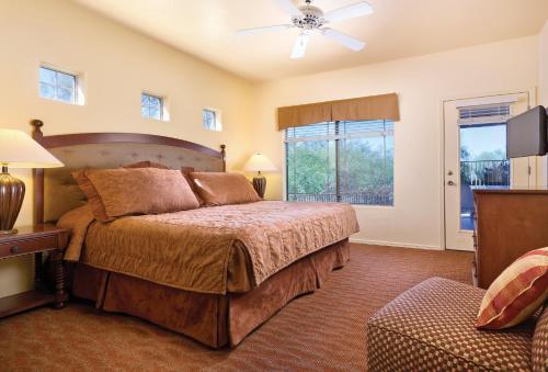 奥罗谷世誉多彩牧场公寓式酒店的一间卧室配有一张床和吊扇