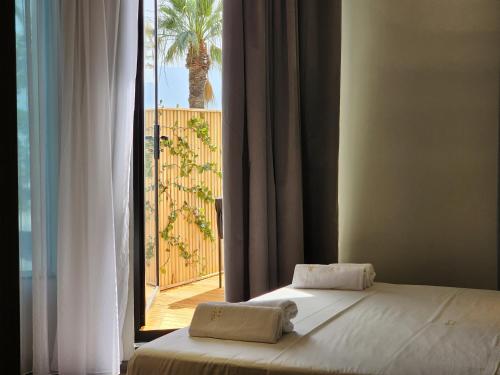 伏罗拉Charm Hotel的一间卧室设有一张床,享有阳台的景色