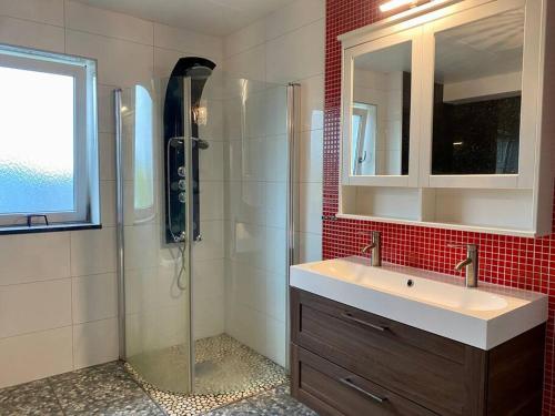 哥德堡Villalägenhet i Askim med havsutsikt的带淋浴、盥洗盆和镜子的浴室