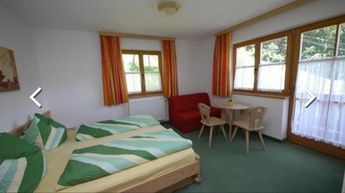 施图默尔贝格Gästehaus Bonholz的一间卧室配有两张床、一张桌子和一把椅子