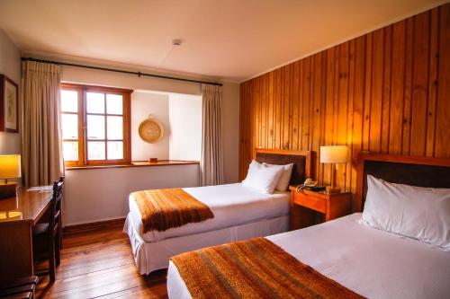 瓦尔迪维亚Hotel Costanera - Caja Los Andes的酒店客房设有两张床和窗户。