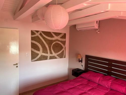 图努扬Dos Aguas的一间卧室配有红色的床和绘画
