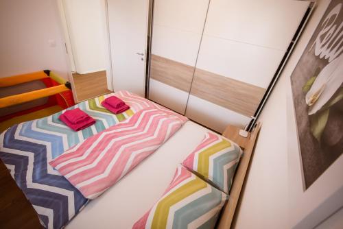 摩拉瓦托普利采Apartma Sofija, Moravski Dvori的小卧室配有色彩缤纷的床单
