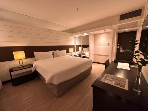 巴西利亚库比契克广场酒店的酒店客房设有一张大床和一张书桌。