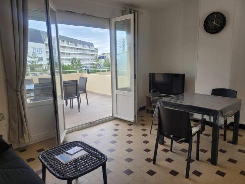 滨海贝尔克Appartement familial terrasse vue mer avec parking的一间带桌椅的客厅和一个阳台