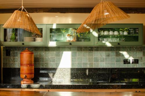 杰里科科拉Pousada Carioca - Pousada de Charme的厨房配有带水槽上方两个灯的台面