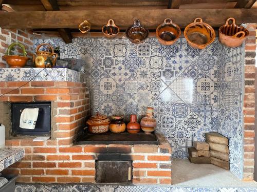 底拉斯卡拉Hotel RioMiel Tlaxcala的墙上的砖炉,炉子上放着锅和平底锅