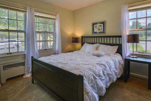 坎伯兰Cumberland Cottage with Screened Porch and Fire Pit!的一间卧室设有一张大床和两个窗户。