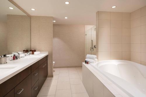 内珀维尔芝加哥内珀维尔万豪酒店的带浴缸、两个盥洗盆和淋浴的浴室。