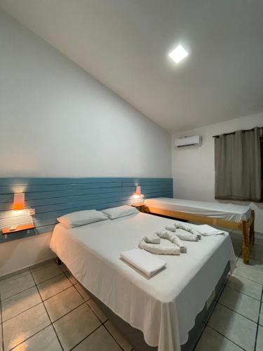 纳塔尔Pousada Encanto dos Mares的一间卧室配有两张带毛巾的床