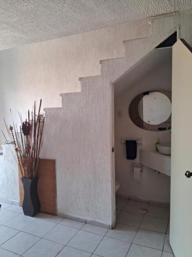 CoyucaCasa Laguna的一间带楼梯、卫生间和花瓶的浴室